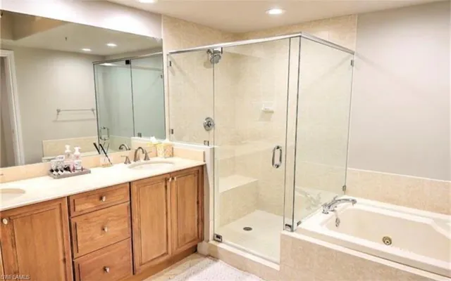 a bathroom with a tub sink shower and mirror