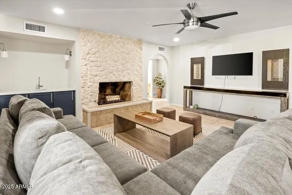 a living room with furniture a flat screen tv and a fireplace
