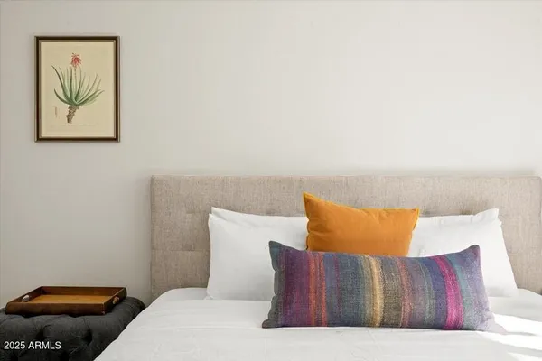 a bedroom with a bed and painting on the wall