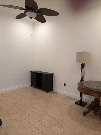 a view of an empty room and chandelier fan
