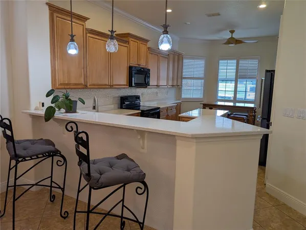 a kitchen with stainless steel appliances kitchen island granite countertop a sink a stove a dining table and chairs