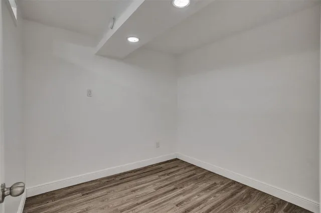 a view of an empty room with wooden floor