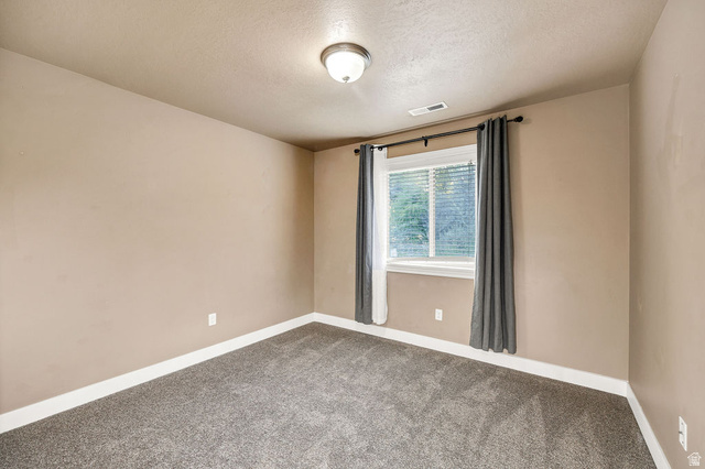 778 South 650 West Logan, UT 84321 - Photo 15 of 26 Bdrm 1 Carpeted room with a window featuring blinds and dark drapery panels