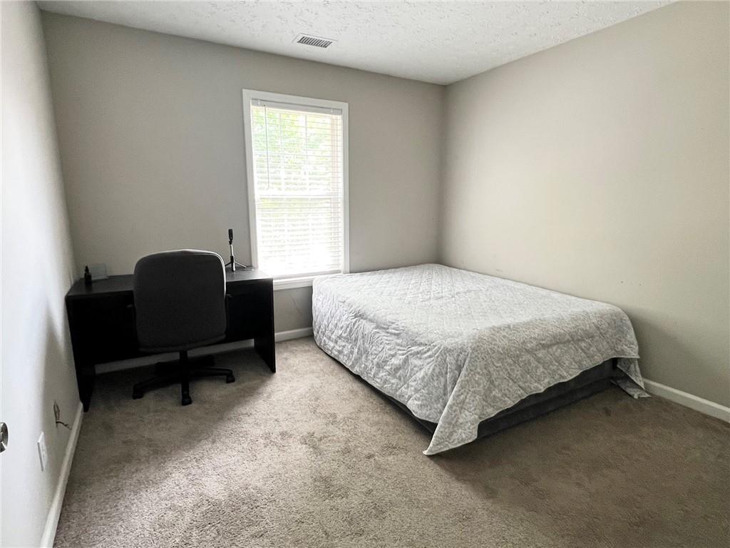 225 Lee Court Canton, GA 30115 - Photo 13 of 18 a bedroom with a bed chair and a window