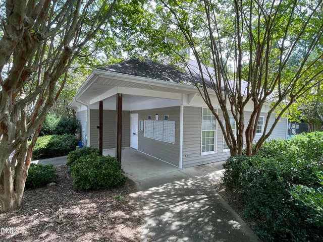 a view of a house with a yard potted plants and large tree