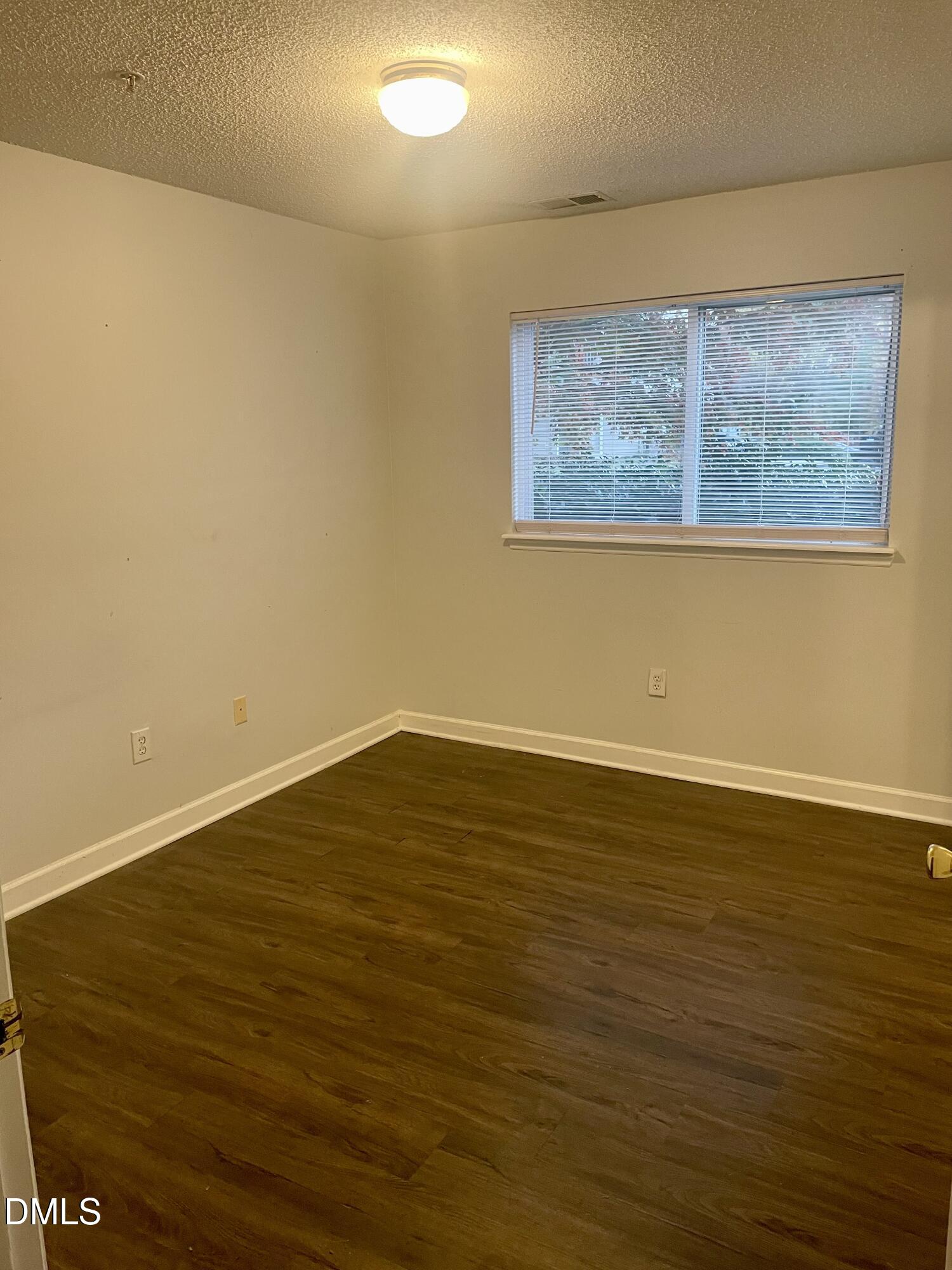 303 Smith Level Road, Unit C12 Chapel Hill, NC 27516 - Photo 6 of 18 a view of an empty room with wooden floor and a window