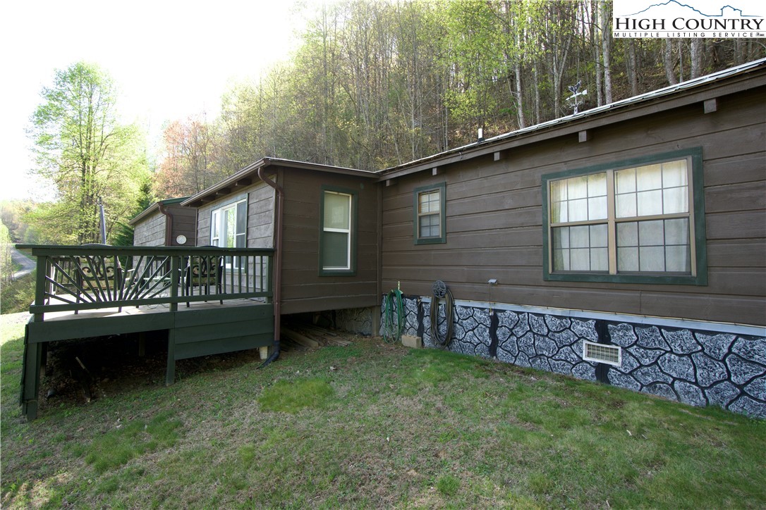 a view of a house with a wooden deck and a yard