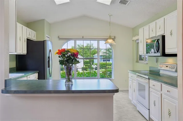 a kitchen with stainless steel appliances granite countertop a sink and a refrigerator