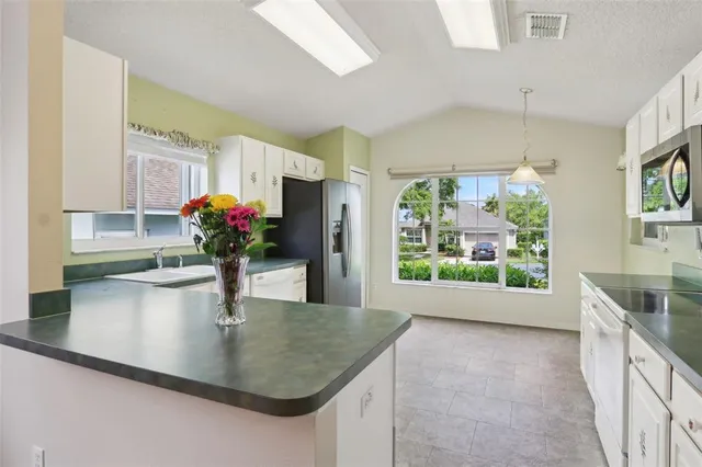 a kitchen with kitchen island a stove and a sink
