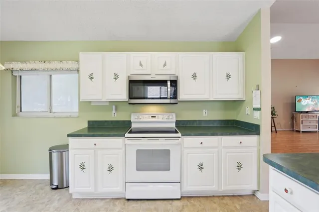 a kitchen with white cabinets and white appliances