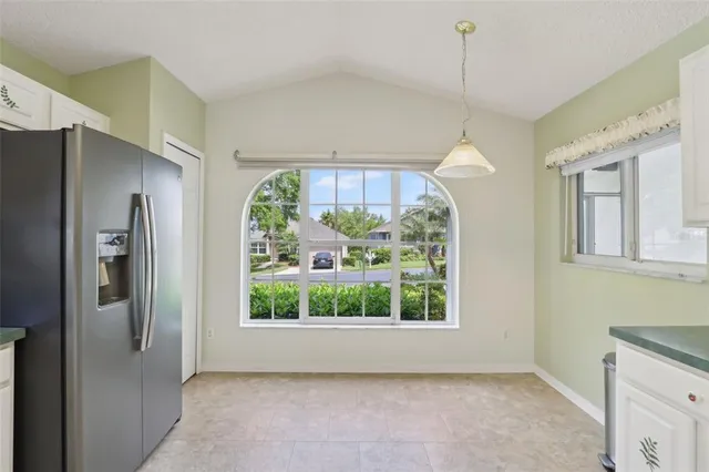 a view of a kitchen with a fridge wooden floor and a chandelier