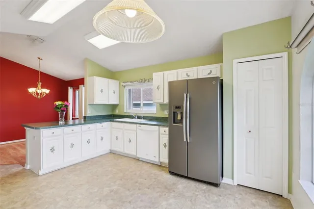 a kitchen with granite countertop a refrigerator and a sink