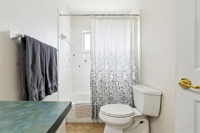 a bathroom with a toilet and a shower