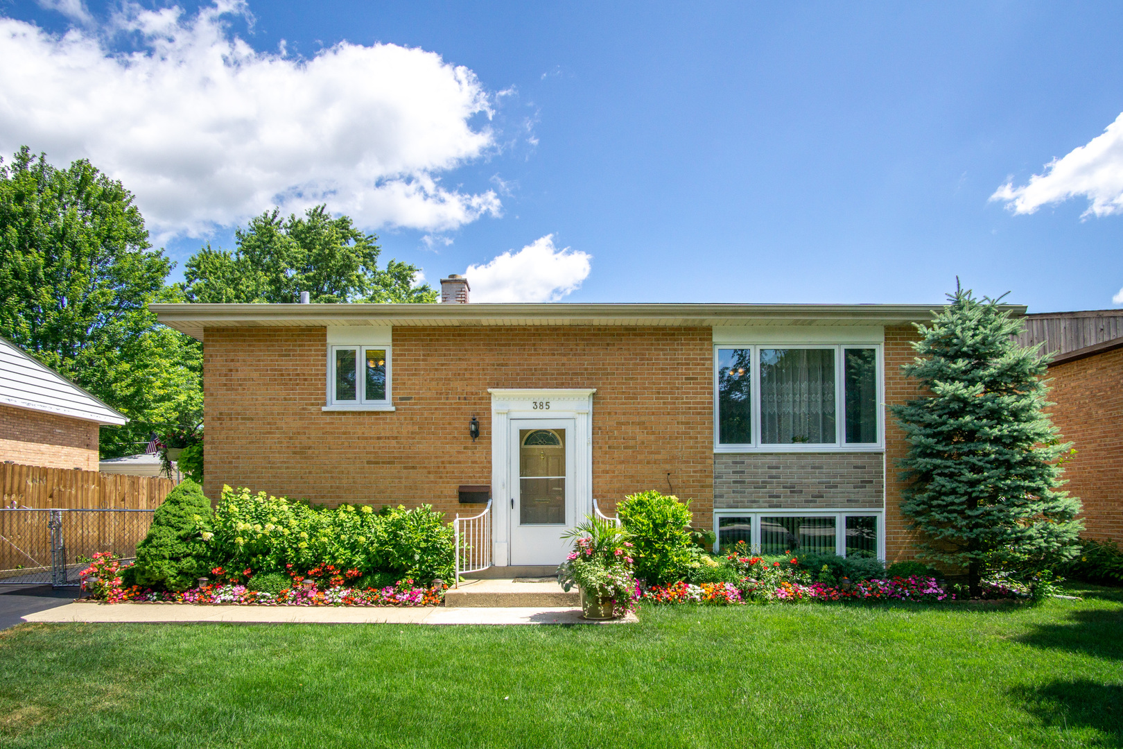 385 South Wolf Road Wheeling, IL 60090 - Photo 1 of 14 a front view of a house with a garden and plants