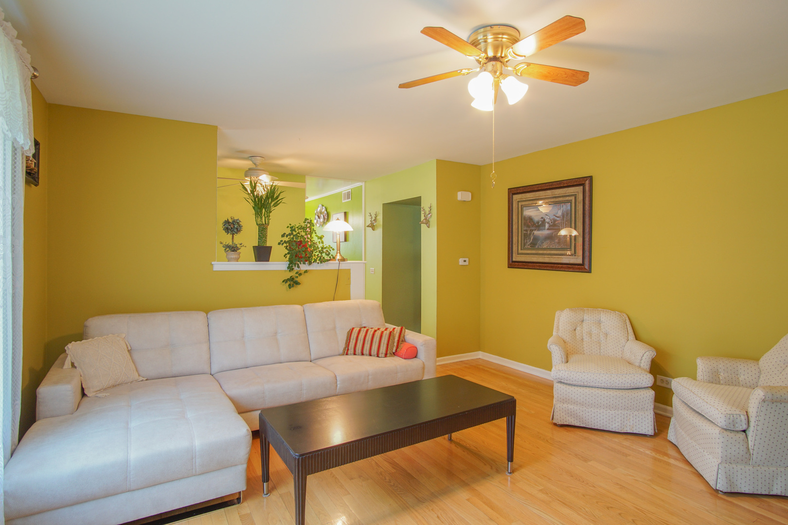 385 South Wolf Road Wheeling, IL 60090 - Photo 2 of 14 a living room with a couch and a chandelier