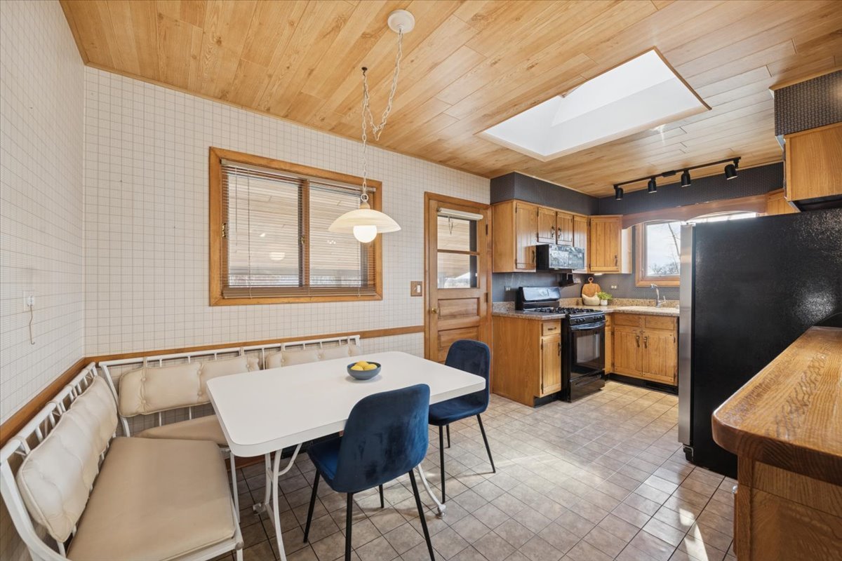 1814 Illinois Road Northbrook, IL 60062 - Photo 9 of 36 a kitchen with a table chairs refrigerator and cabinets