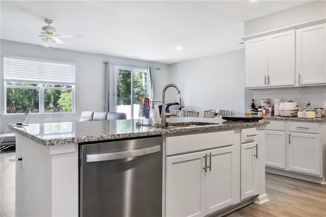 a kitchen with granite countertop a sink white cabinets and a granite counter tops