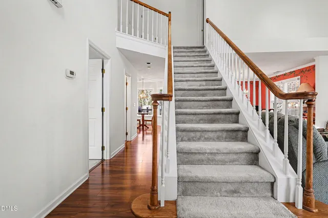 a living room with stainless steel appliances granite countertop furniture and a chandelier