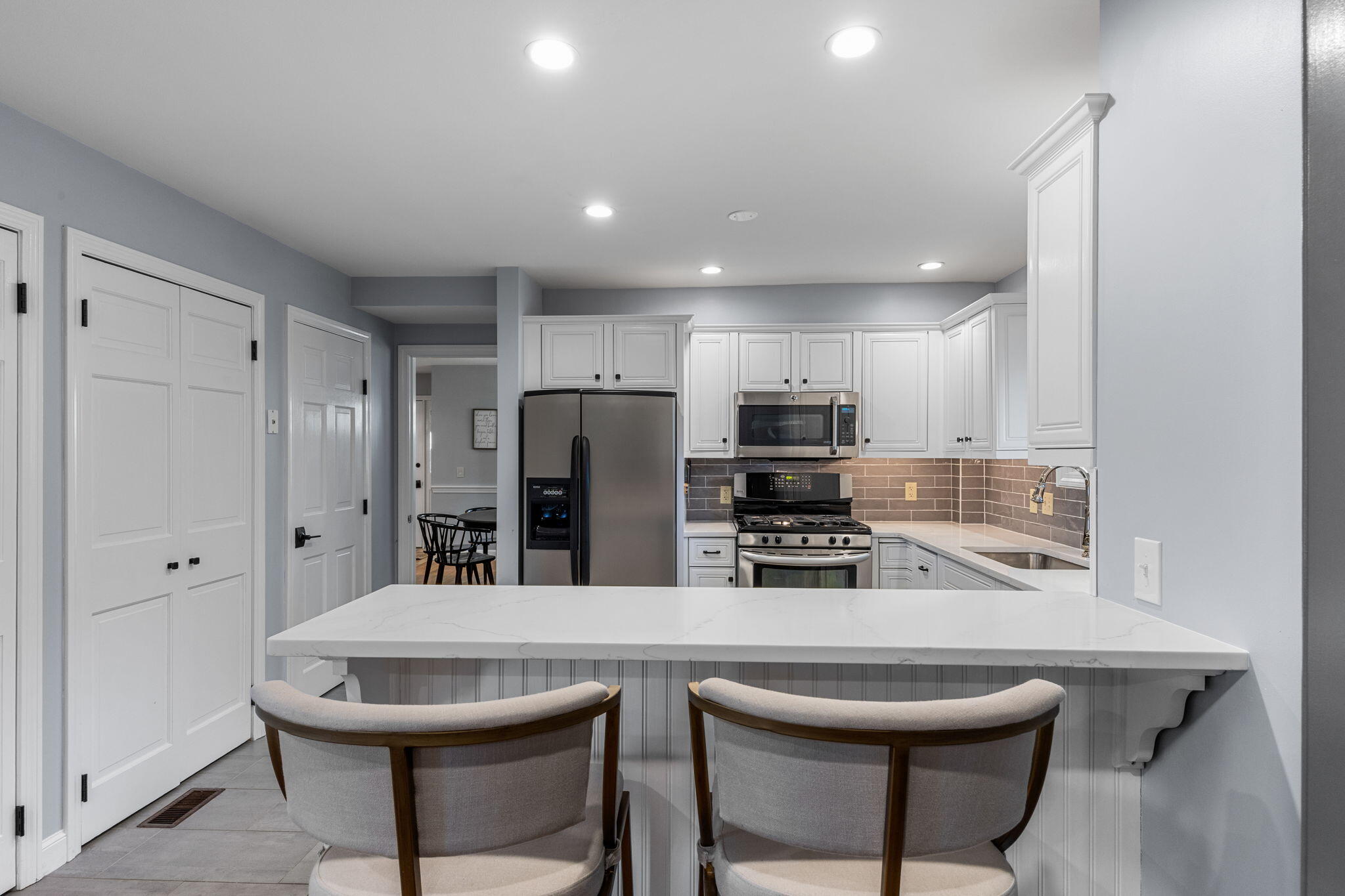 2 Dogwood Road, Unit 2 Buzzards Bay, MA 02532 - Photo 23 of 49 a kitchen with stainless steel appliances a dining table chairs refrigerator and microwave