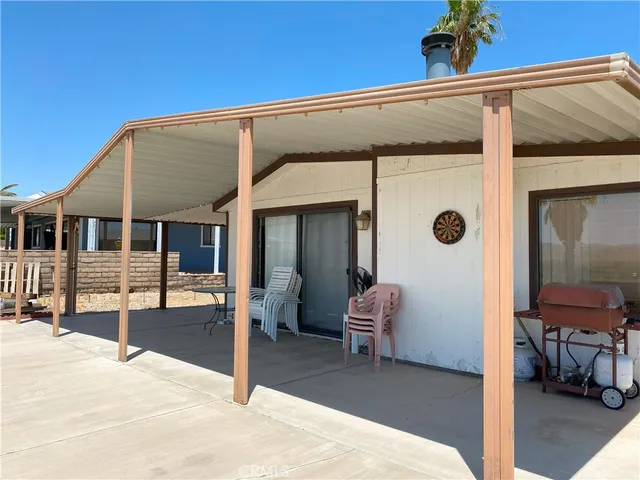 a view of a house with a barbeque and bench and floor to ceiling window