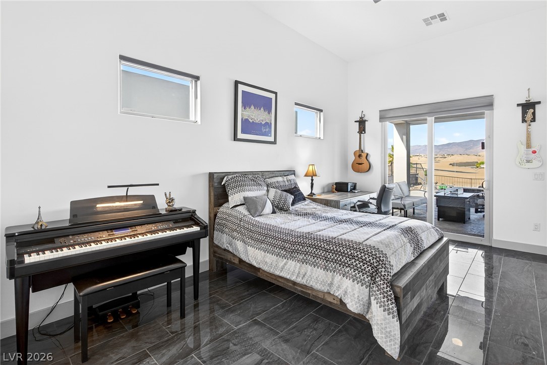 1460 Blue Ridge Trail Mesquite, NV 89027 - Photo 16 of 39 Natural light pours into this bedroom, featuring soaring ceilings and sleek tiled flooring.