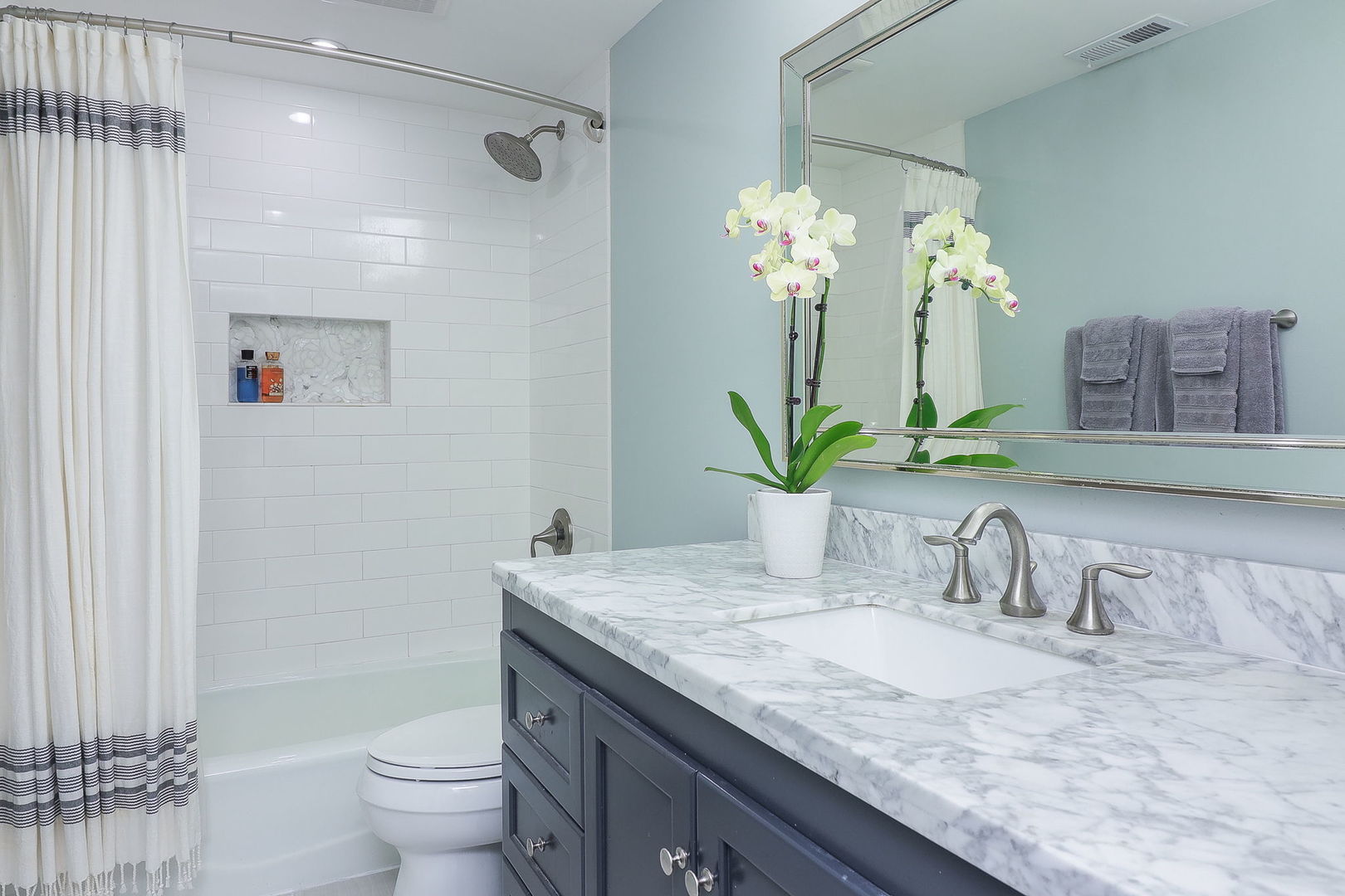 1346 North Sutton Place Chicago, IL 60610 - Photo 19 of 25 a bathroom with a granite countertop sink a toilet and a mirror