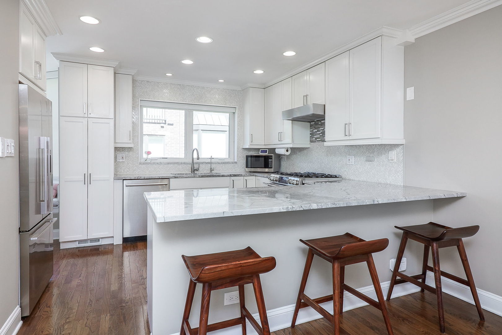 1346 North Sutton Place Chicago, IL 60610 - Photo 7 of 25 a kitchen with stainless steel appliances granite countertop a table chairs sink refrigerator and cabinets