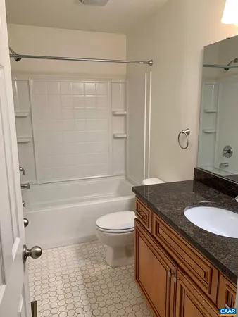 a bathroom with a granite countertop sink toilet a mirror and shower