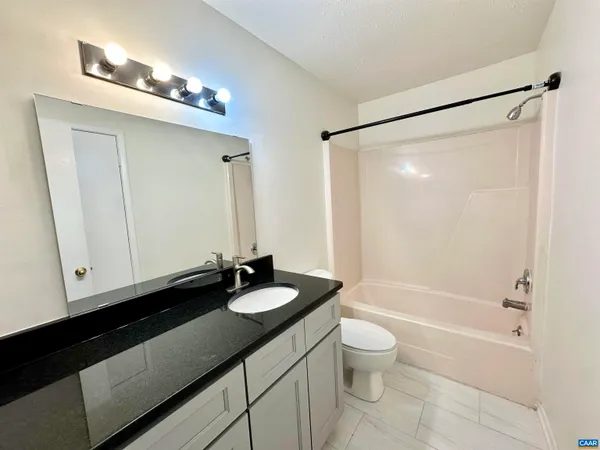 a bathroom with a double vanity sink toilet mirror and shower