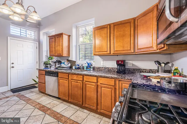 a kitchen with stainless steel appliances granite countertop a stove a sink and a refrigerator
