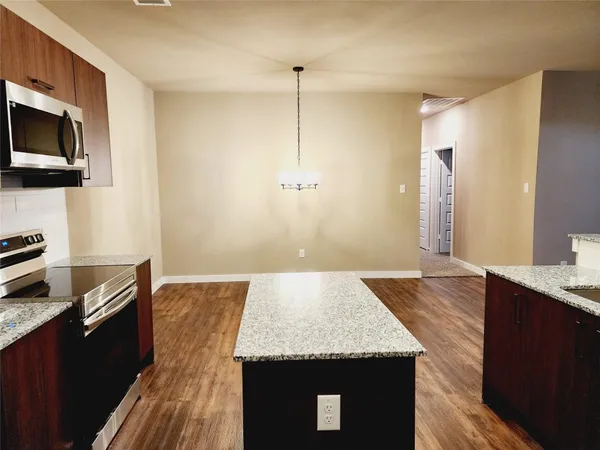 a kitchen with kitchen island a sink stainless steel appliances and wooden floor