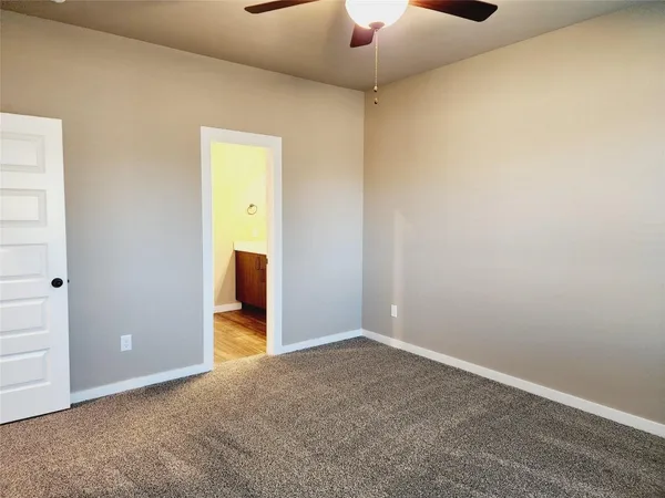 an empty room with closet and a chandelier fan