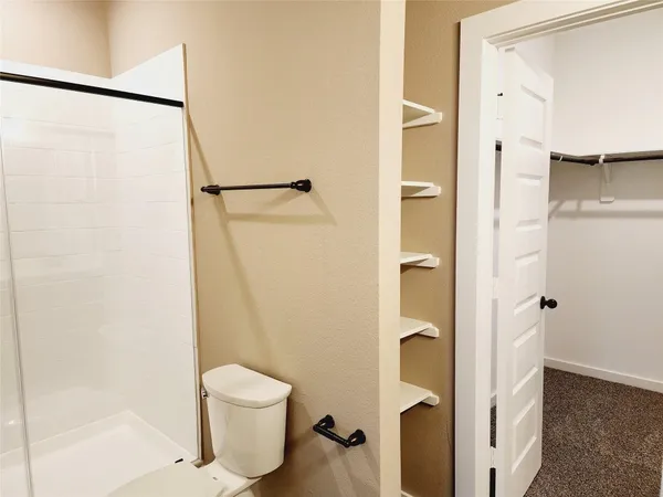 a bathroom with a toilet and a shower