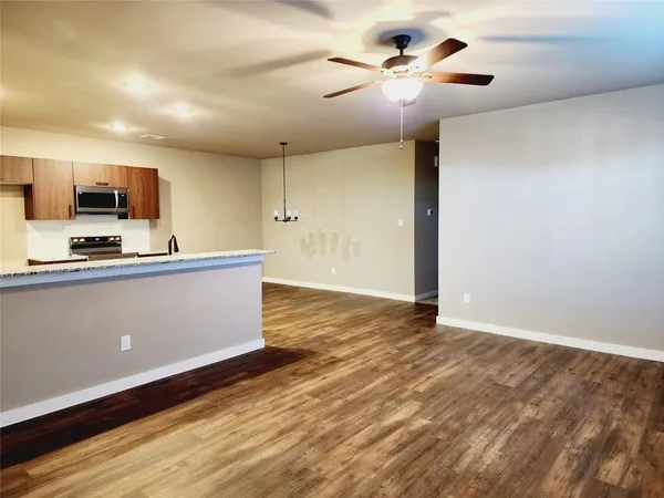 a view of kitchen with wooden floor and a ceiling fan