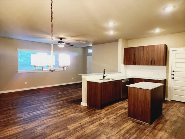a kitchen with stainless steel appliances granite countertop a sink a stove and a wooden floors