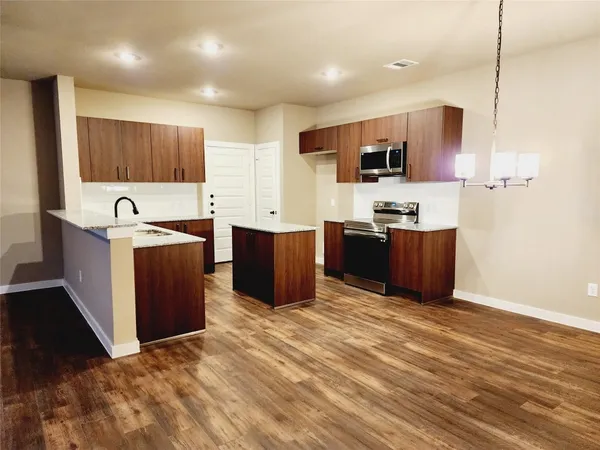 a large kitchen with stainless steel appliances granite countertop a sink and a stove