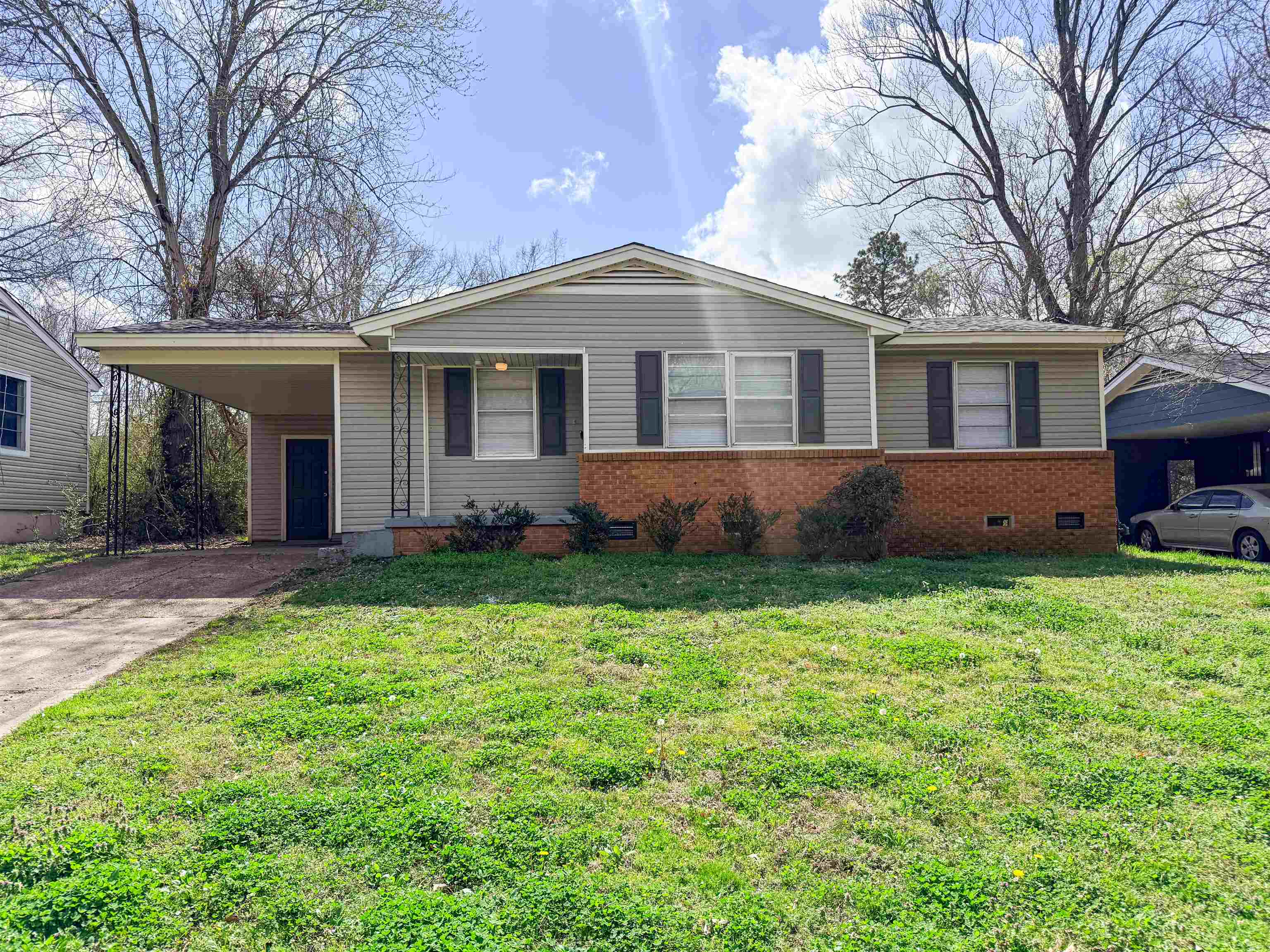 655 West Raines Road Memphis, TN 38109 - Photo 1 of 18 View of front of home featuring crawl space, a carport, driveway, and a front lawn