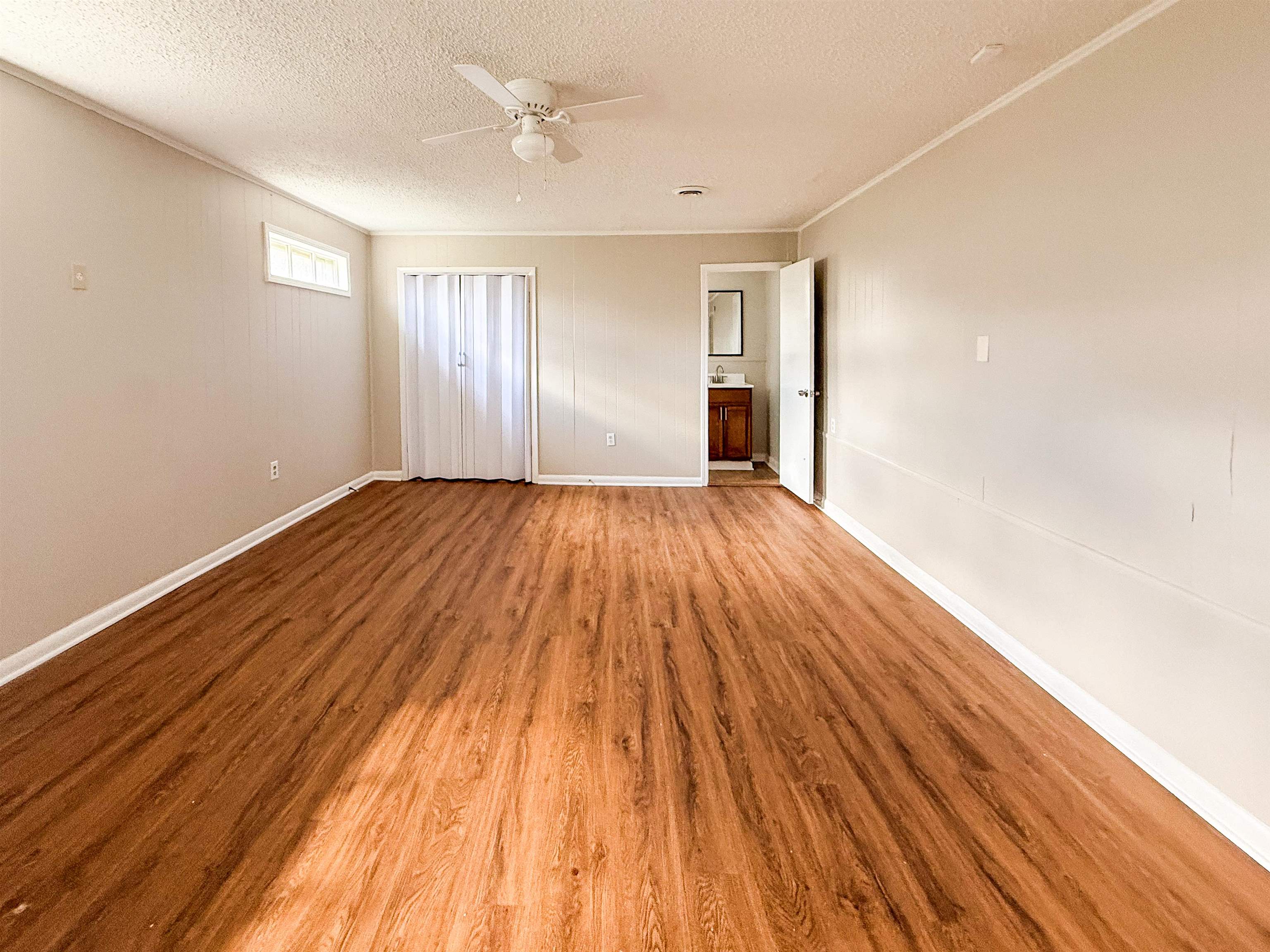 655 West Raines Road Memphis, TN 38109 - Photo 11 of 18 Unfurnished bedroom featuring light wood-style flooring, a ceiling fan, ornamental molding, a textured ceiling, and connected bathroom