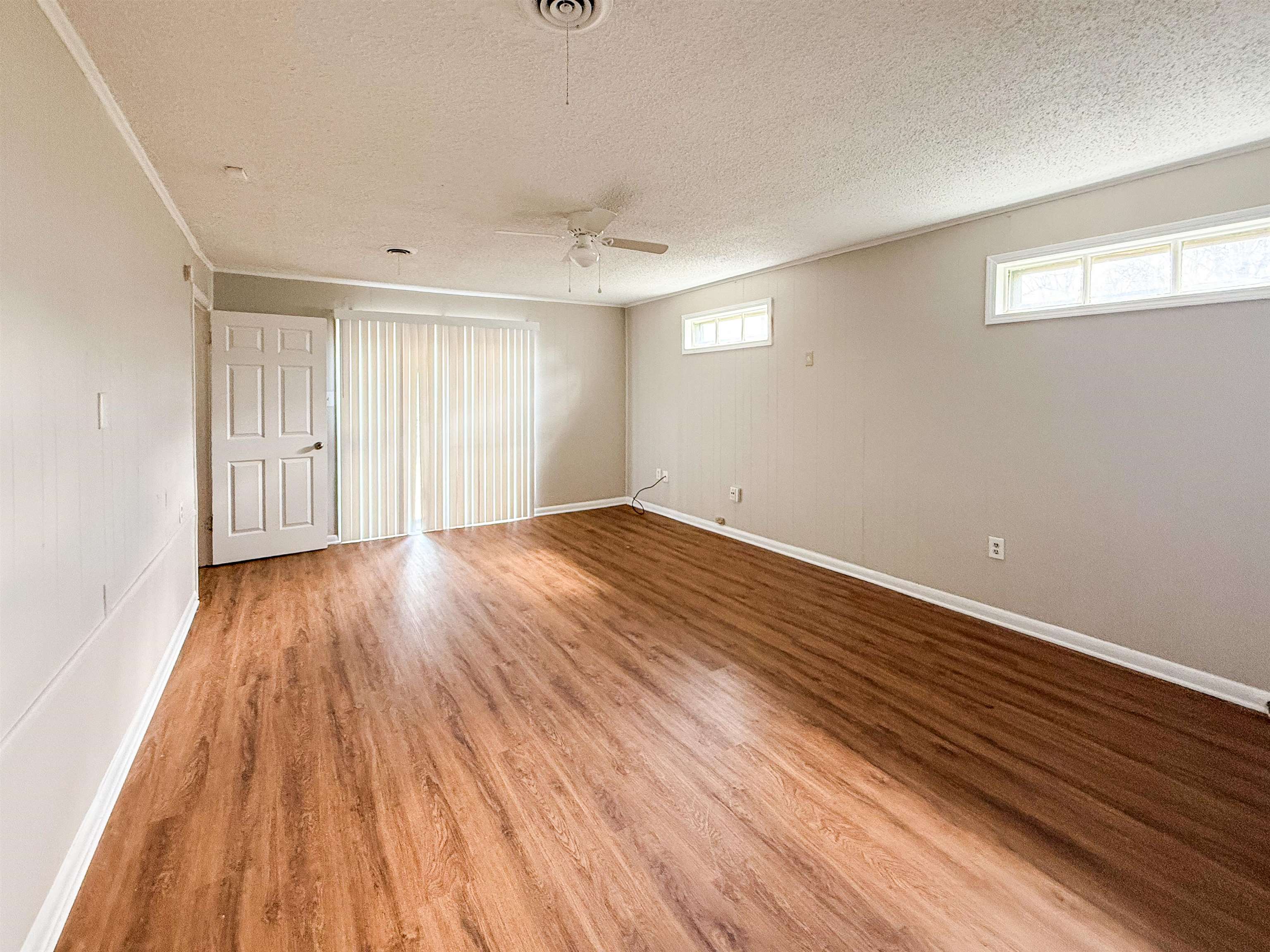 655 West Raines Road Memphis, TN 38109 - Photo 12 of 18 Unfurnished room featuring light wood-style flooring, a ceiling fan, and a textured ceiling