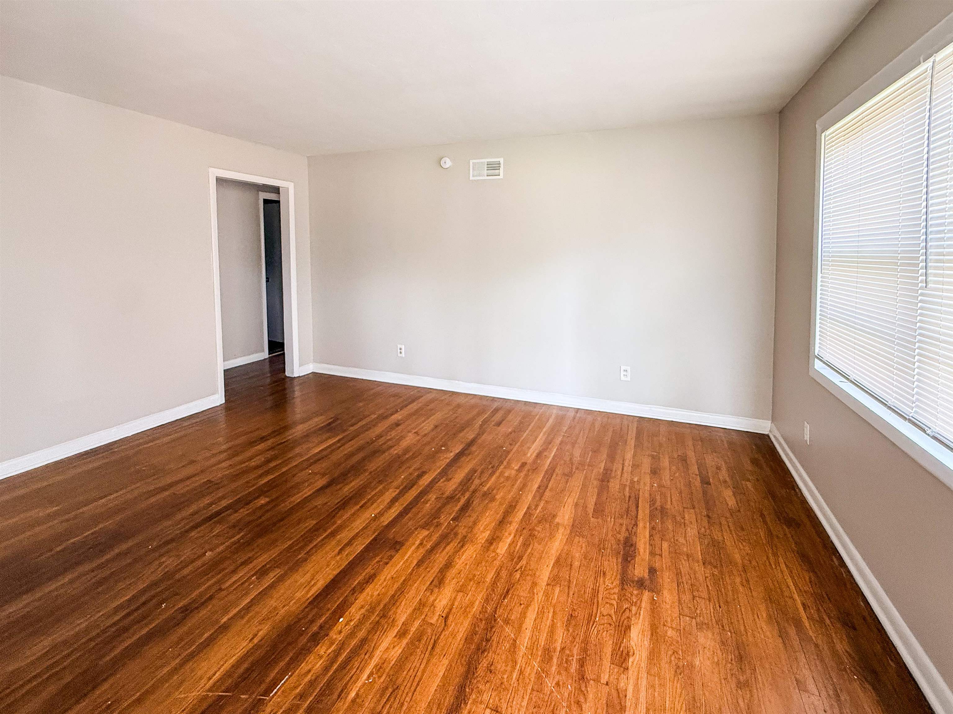 655 West Raines Road Memphis, TN 38109 - Photo 2 of 18 Unfurnished room with dark wood finished floors and baseboards