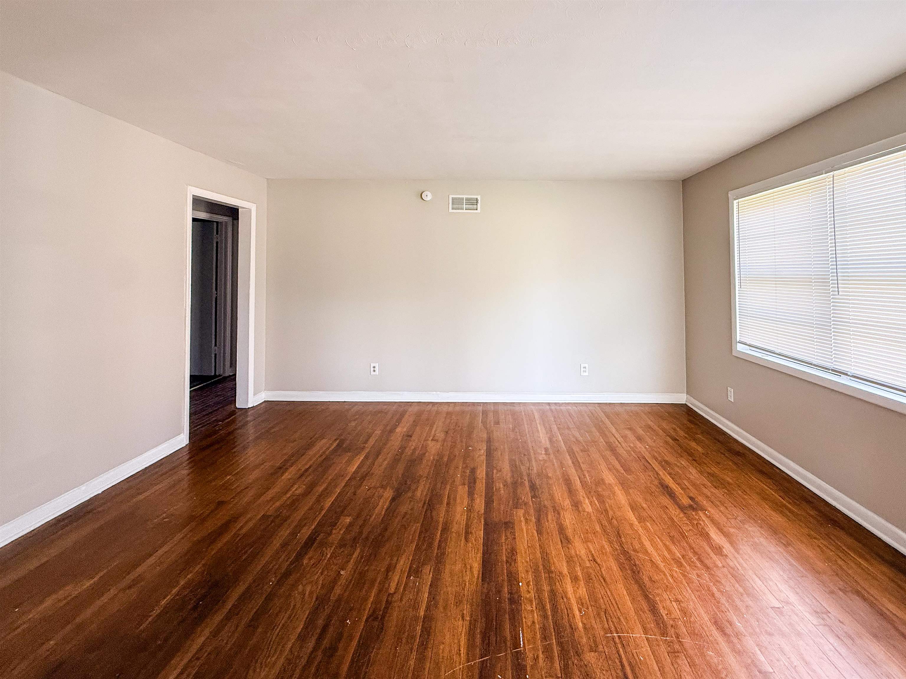 655 West Raines Road Memphis, TN 38109 - Photo 3 of 18 Spare room featuring dark wood-type flooring and baseboards