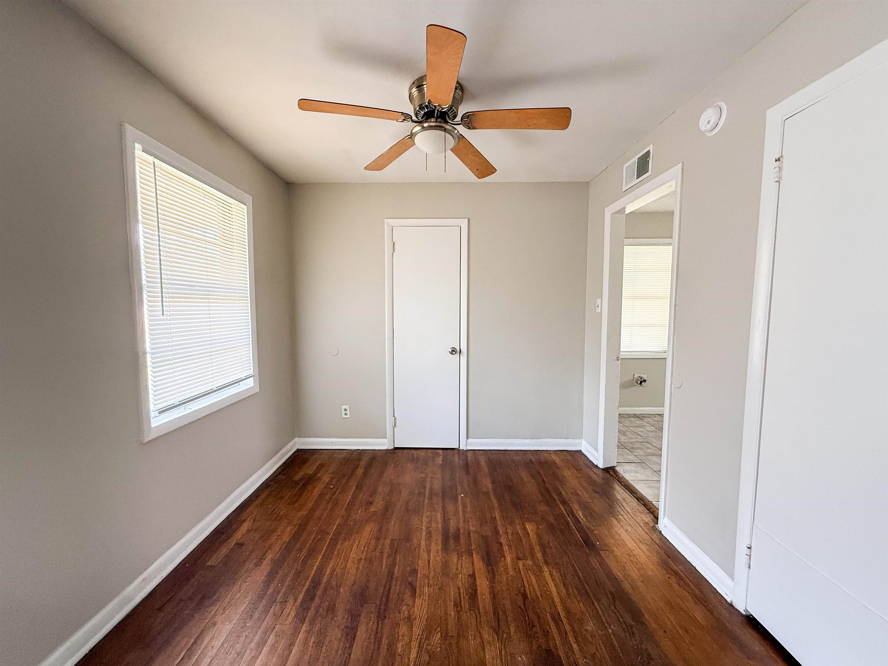 655 West Raines Road Memphis, TN 38109 - Photo 4 of 18 Unfurnished bedroom featuring dark wood finished floors and a ceiling fan