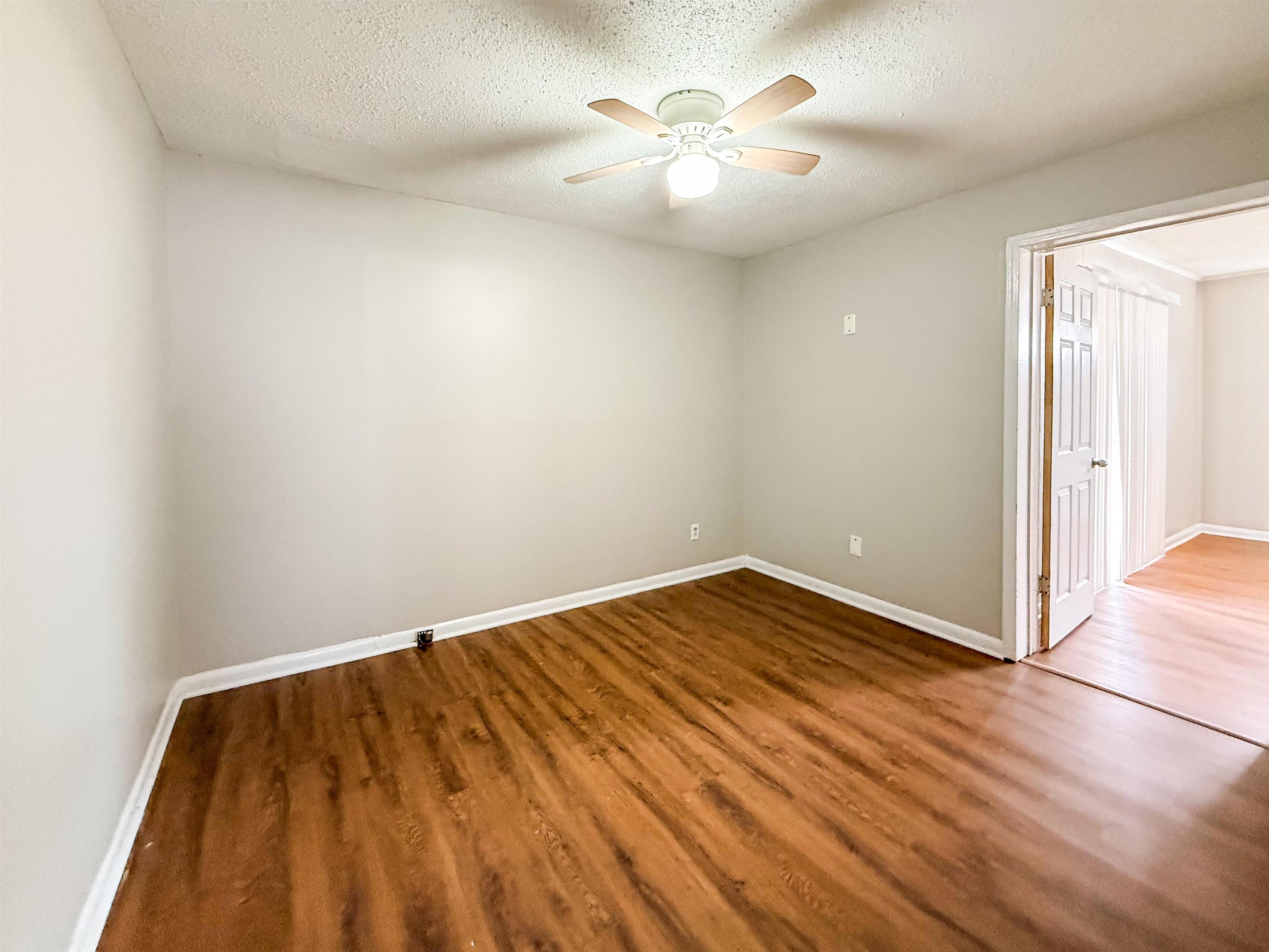 655 West Raines Road Memphis, TN 38109 - Photo 8 of 18 Unfurnished room featuring wood finished floors, a textured ceiling, and a ceiling fan