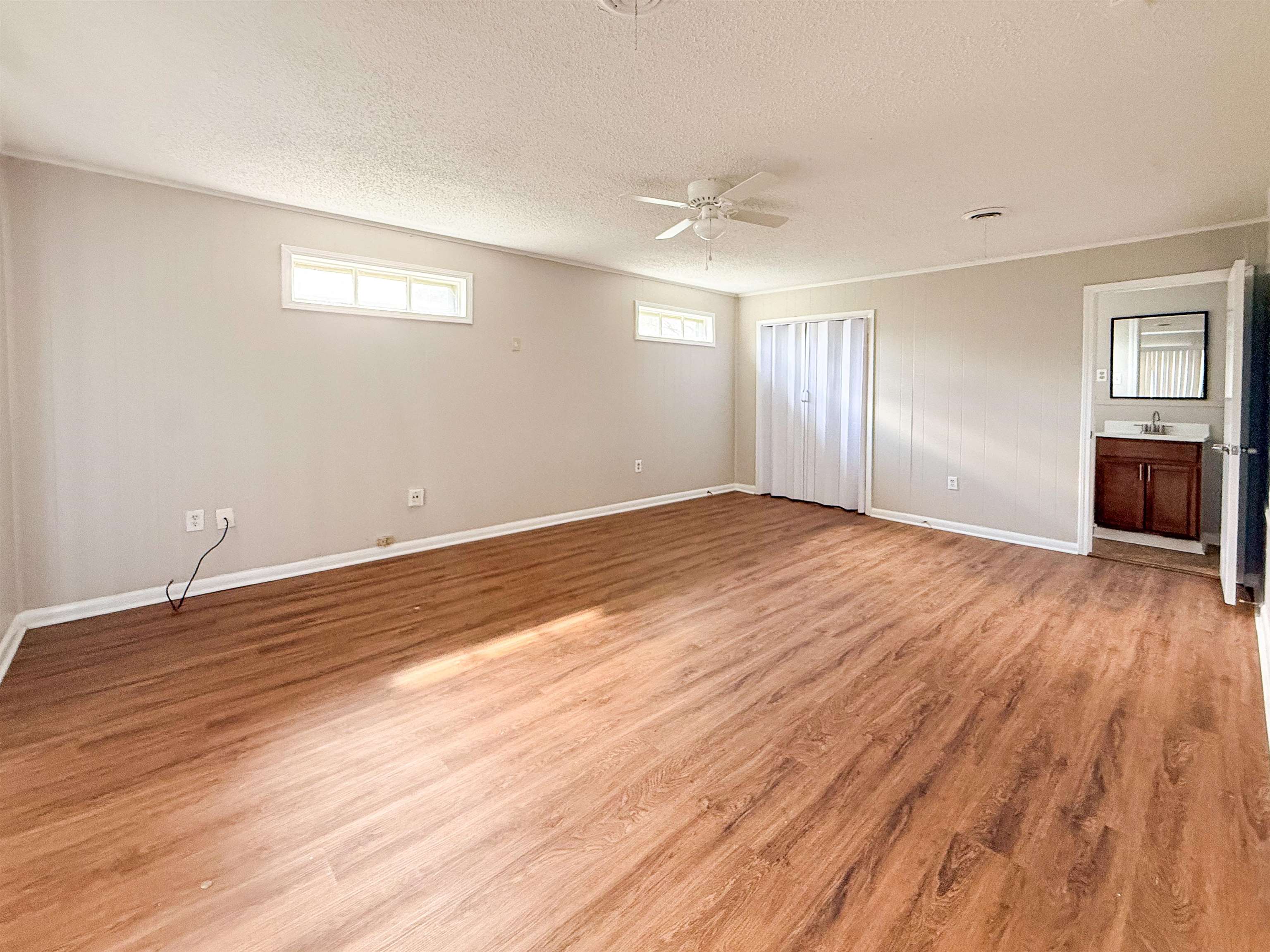 655 West Raines Road Memphis, TN 38109 - Photo 10 of 18 Unfurnished bedroom featuring light wood-style flooring, a ceiling fan, and a textured ceiling