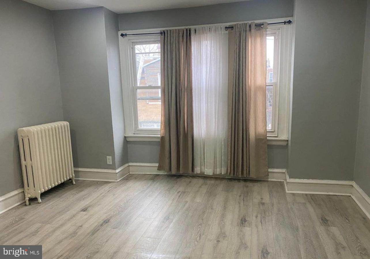 6550 Regent Street Philadelphia, PA 19142 - Photo 4 of 12 an empty room with wooden floor and windows