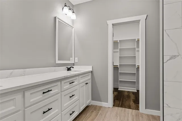 a bathroom with a granite countertop sink and a mirror
