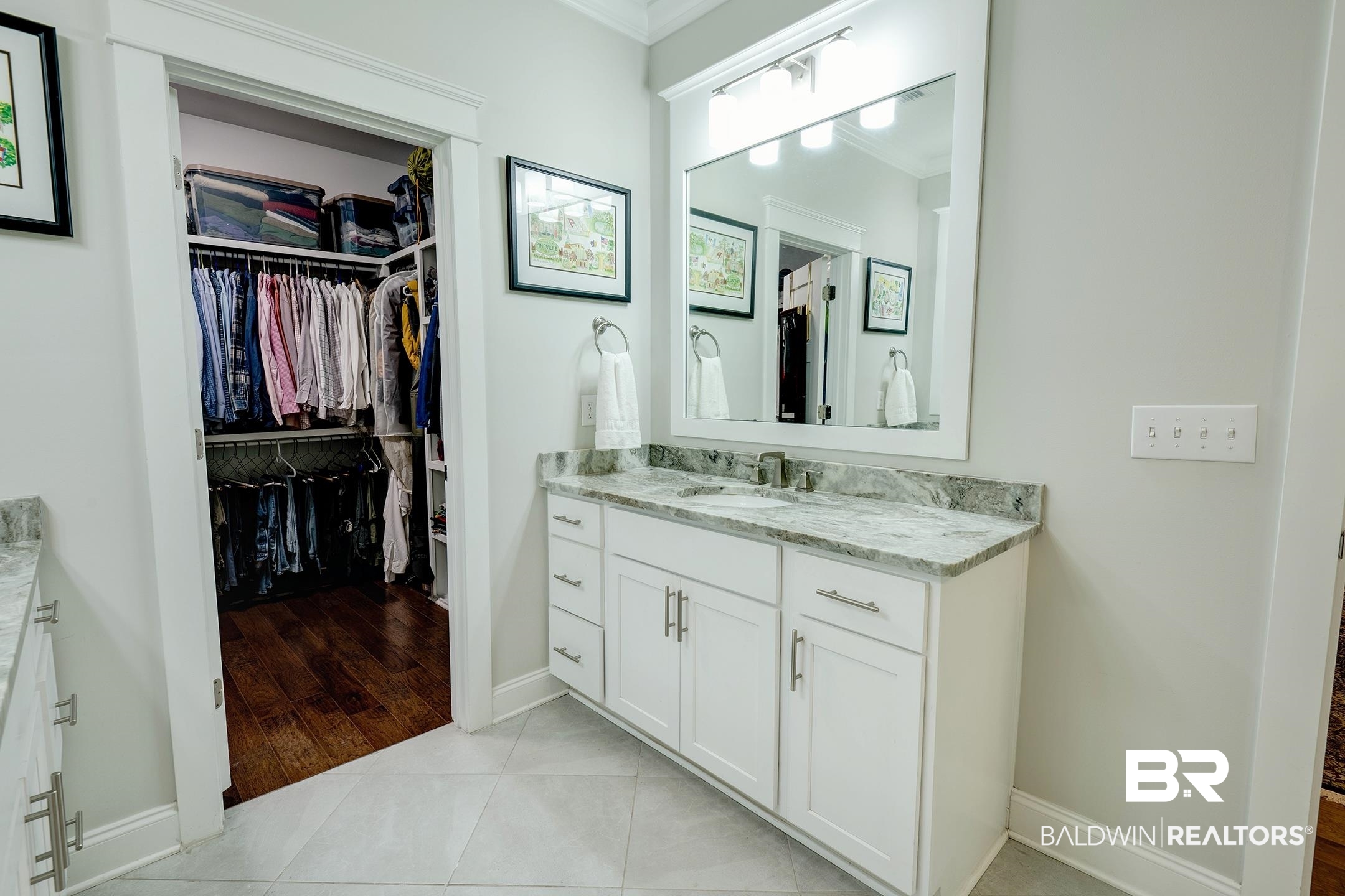 18754 Treasure Oaks Road Gulf Shores, AL 36542 - Photo 19 of 53 Bathroom featuring a white vanity with a single basin sink, granite countertop, and a framed mirror with integrated lighting