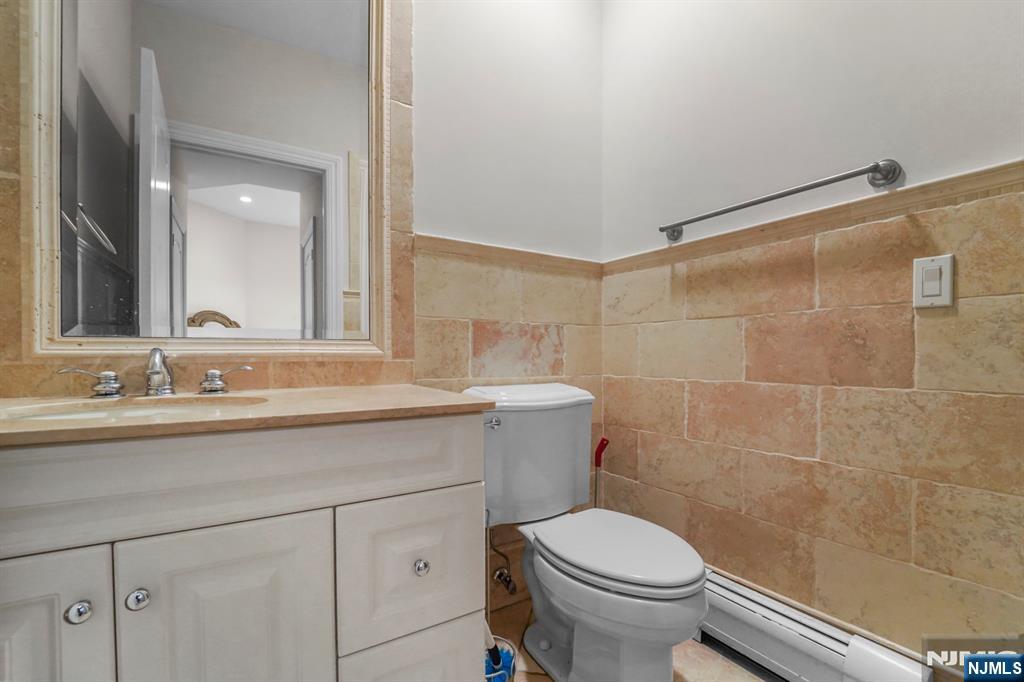 1 Euclid Road Fort Lee, NJ 07024 - Photo 35 of 50 a bathroom with a sink a toilet and a mirror