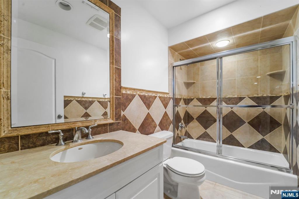 1 Euclid Road Fort Lee, NJ 07024 - Photo 43 of 50 a bathroom with a sink a toilet and a mirror