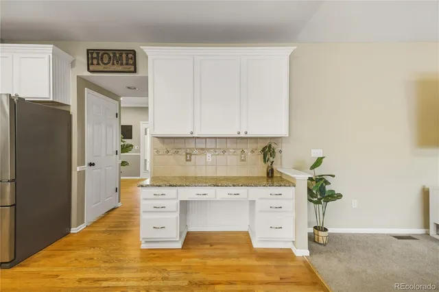 a kitchen with stainless steel appliances white cabinets and a refrigerator